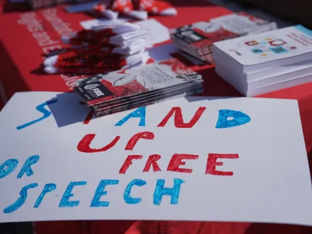 FIRE table at University of Illinois Urbana Champaign with a sign on the corner that reads "stand up for free speech". Photography by Sylwia Sawicka.