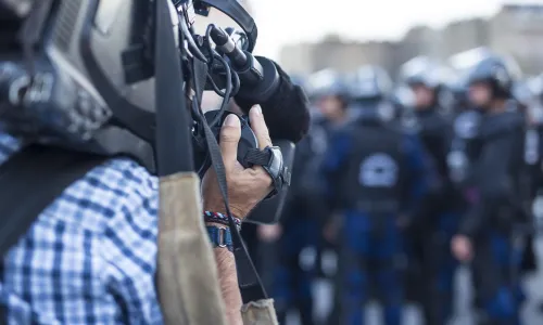 News cameraman films police on the streets